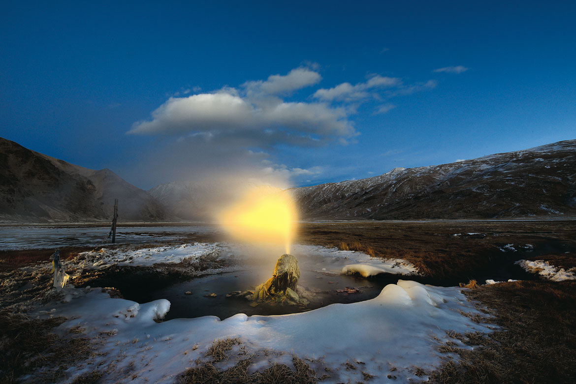 The glow of a headlamp transforms erupting steam and water into a halo around the head of a geyser. Even at a temperature of -25 degrees, the water is a scalding 80 degrees celcius, the boiling point at 4,000m above sea level