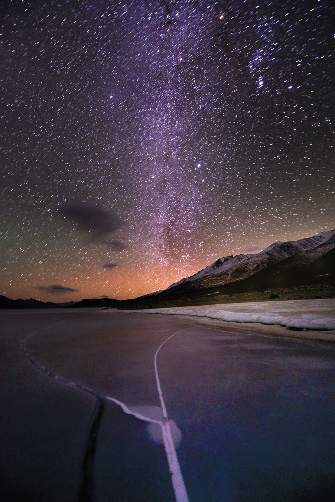 A crack on the frozen Pangong Tso reflects the Milky Way that arches over it. Cloudless new moon nights on the Changthang are often bright enough for stars to paint the lake ice