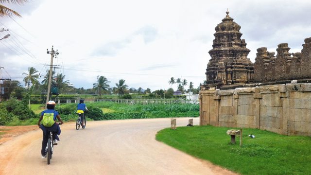 Cyclists ride throught the Nandi Village