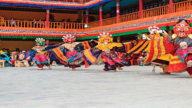 Monks in colourful costumes perform the traditional cham dance