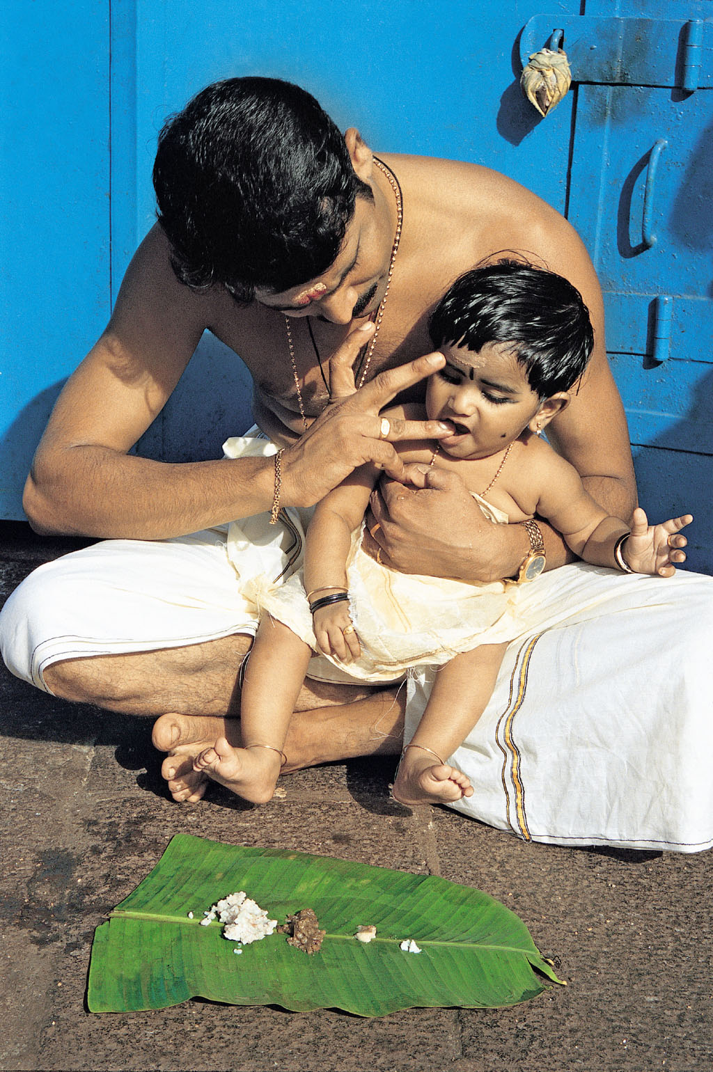 A toddler being fed rice for the first time