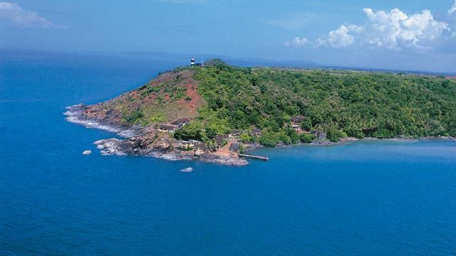 A verdant stretch of land surrounded by blue waters near Vengurla Beach