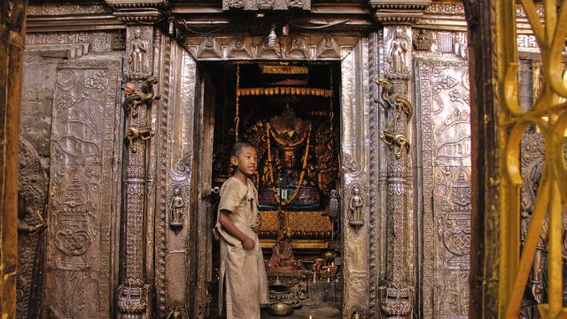 There has been no celibate monastic community amongst the Newars from at least the 16 century. Sometime around then, the Buddhists of the Kathmandu Valley were divided by the Hindu Malla kings into a 'caste' system. The Vajracharyas and the Sakyas undergo monastic initiation at a young age, guided by the basic framework of the Vajrayana. All of them take turns to care for the Kwapa Dyah, and there is always a young boy priest, the 'bapacha' who tends to the Buddha shrine. Here you see the 'bapacha' at Kwa Baha, at the main shrine of Sakyamuni Buddha.