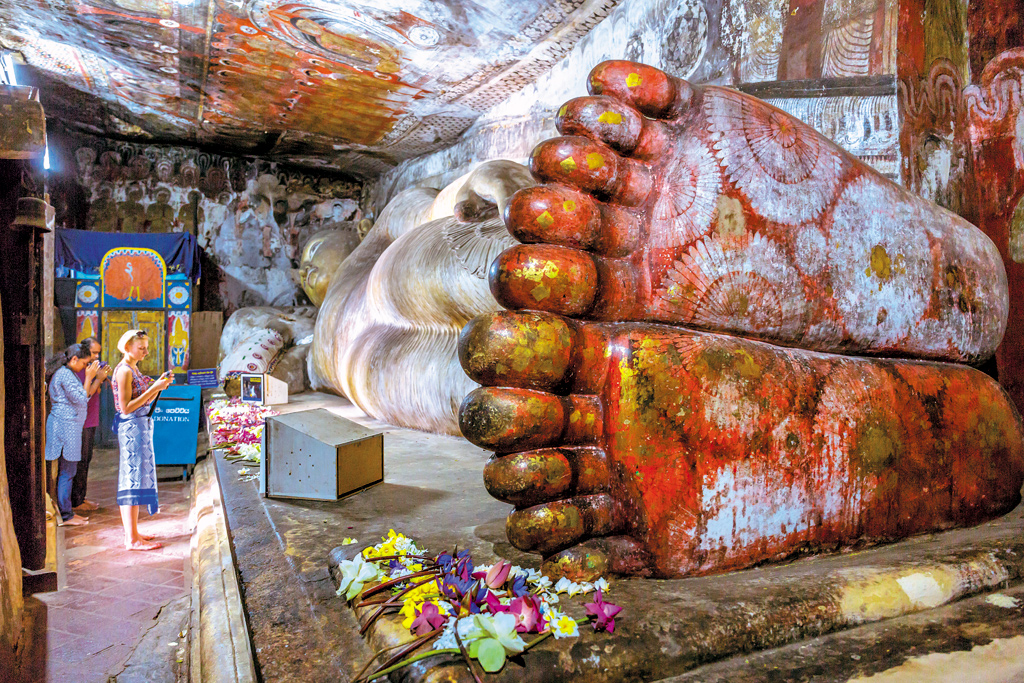 Reclining Buddha at the Dambulla Cave Temple in Sri Lanka. Dating back to the 3rd century BCE, this five-cave complex is still functional as a Buddhist temple. The reclining Buddha is one of 157 statues in the complex.