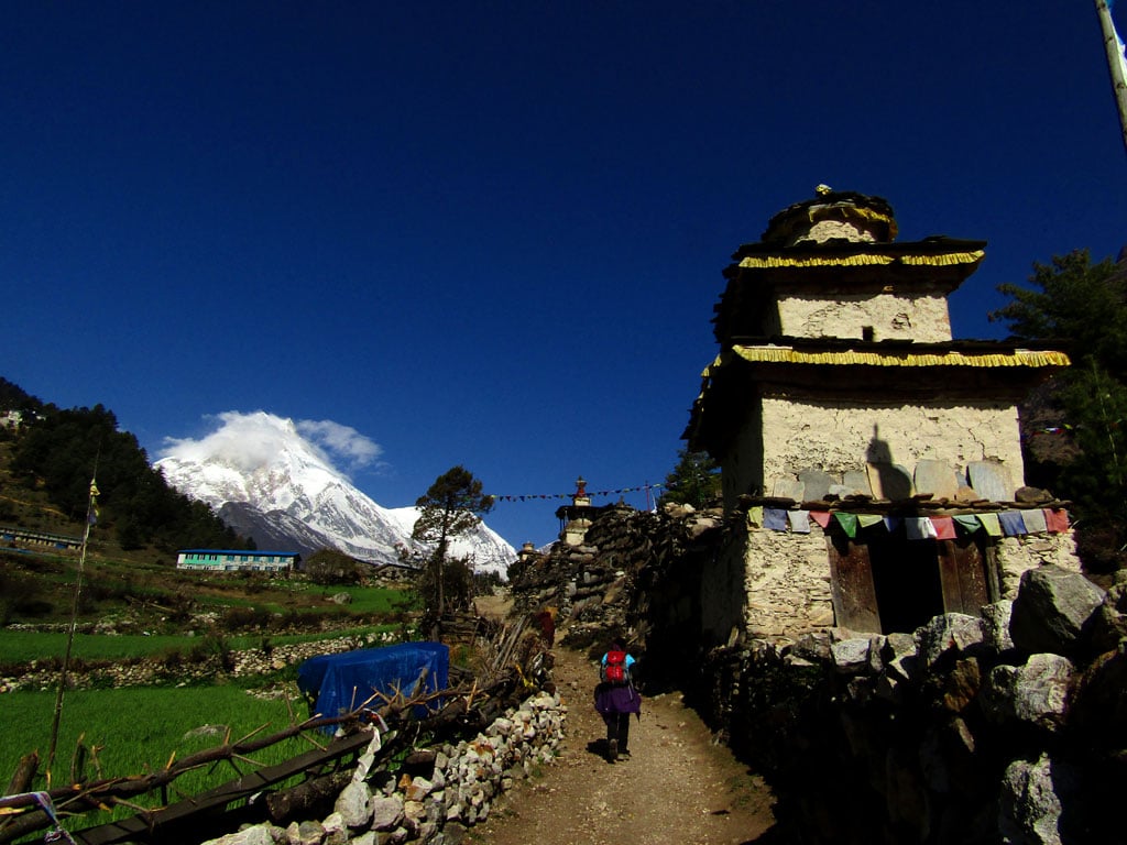 A trekker passes by a Kane gateway in Lho village. The upper villages on the circuit are Tibetan, and Lho is home to the region's biggest Buddhist monastery