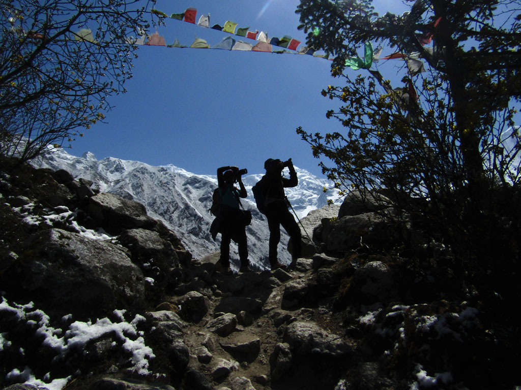 Trekkers taking photographs atop the moraine ridge of Hampuk