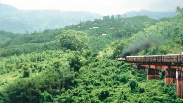 Train steaming past thickly wooded hills, Haflong