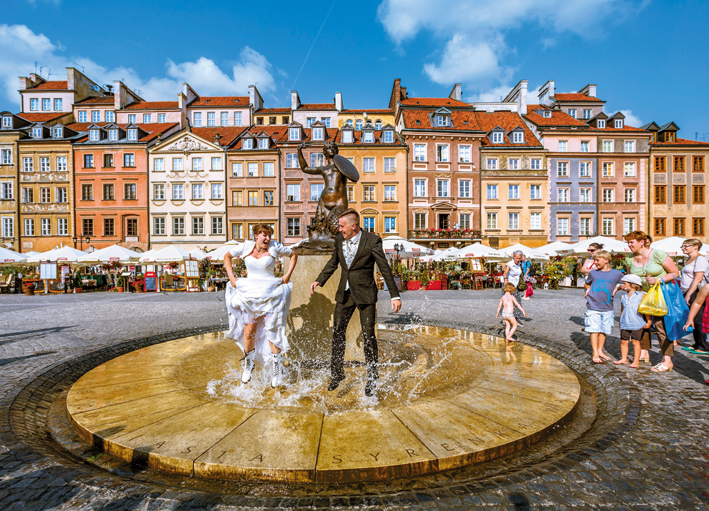 Newly-weds splash around the Mermaid Statue, Warsaw Old Town, Poland. WWII saw 85 per cent of the historic centre destroyed, but over five years the old town was completely rebuilt—a feat that catapulted it into the UNESCO list.