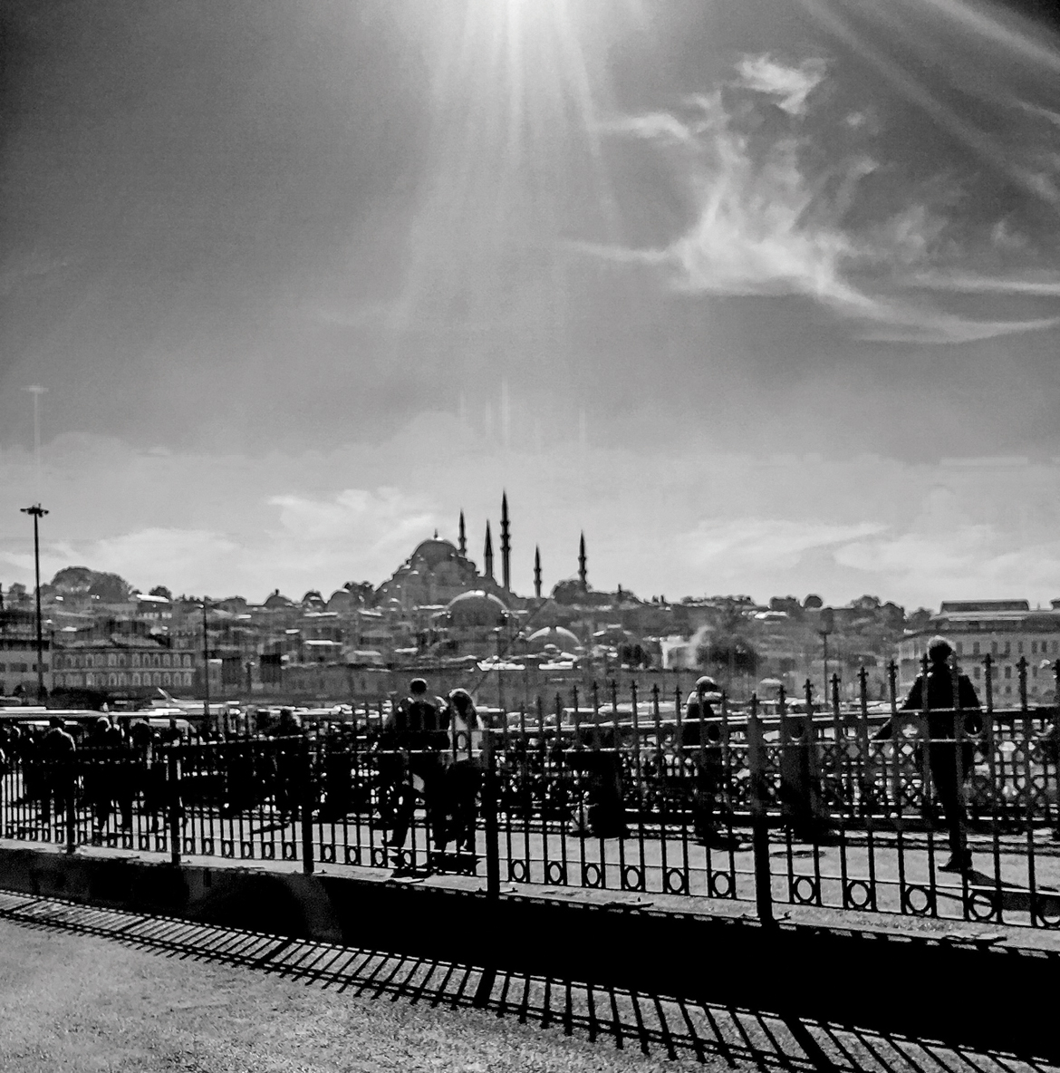 People taking a stroll on a bridge overlooking the city