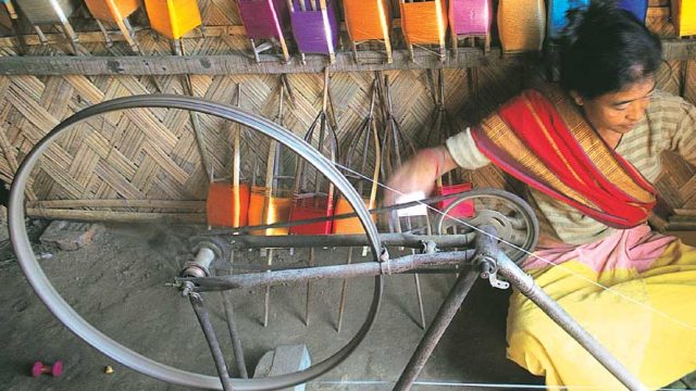 A weaver spinning silk thread, Sualkuchi village, Assam