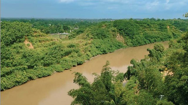 The muddy Gomati river flowing past a lush landscape