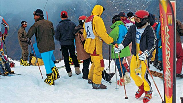 Skiiers gathered atop a slope