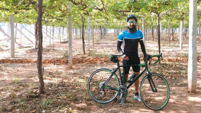 The author poses with his bicycle in a vineyard