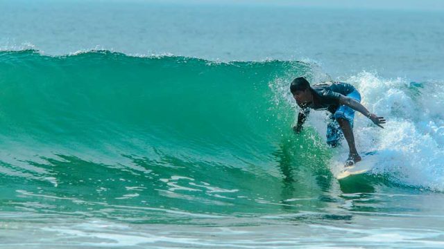 A surfer rides a wave