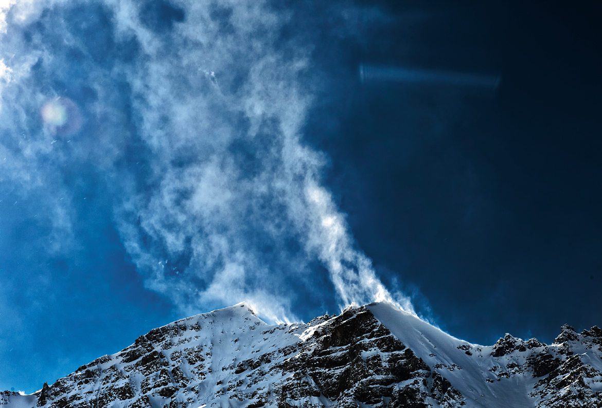 High winds create magnificent snow plumes atop the summit of Stok Kangri.