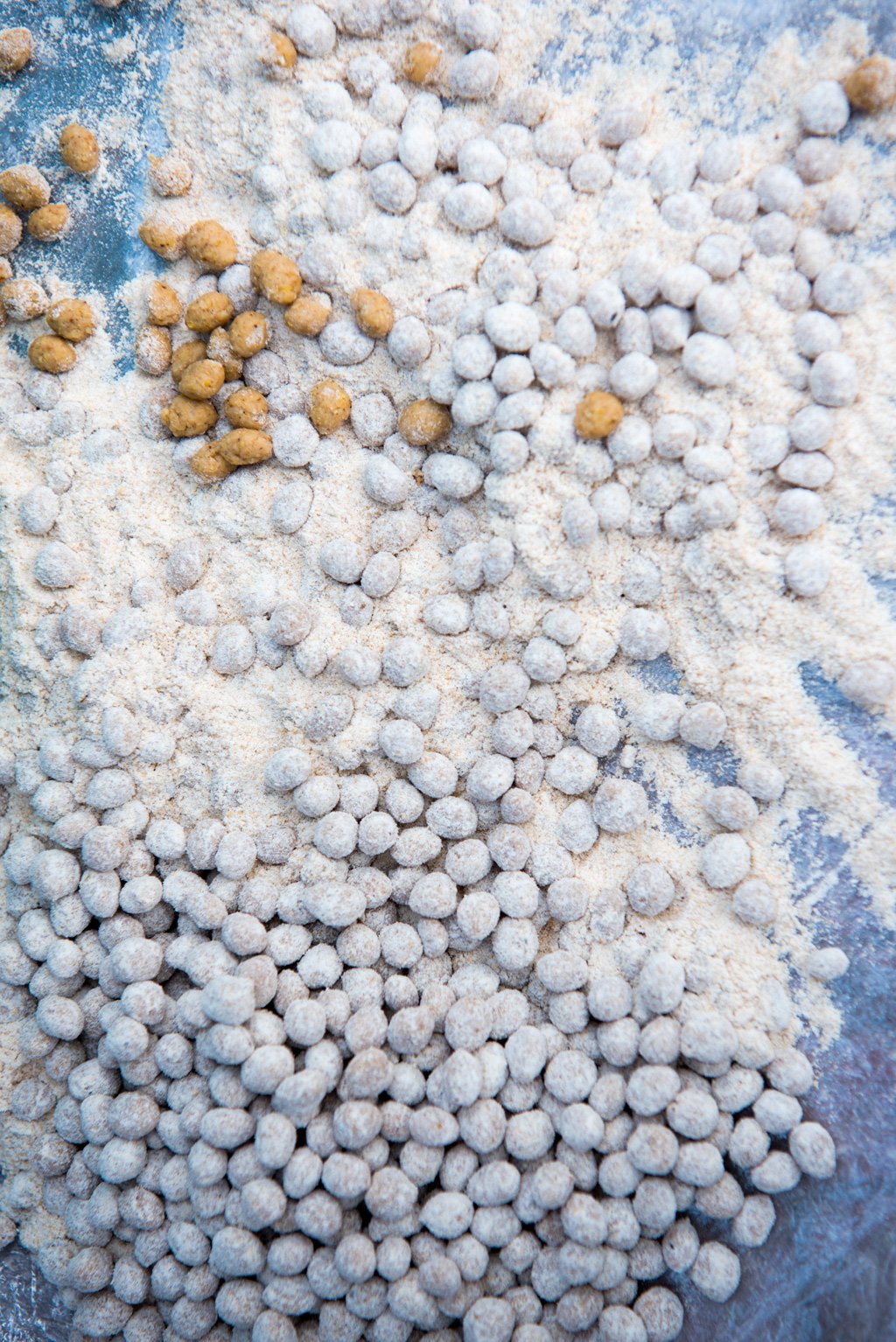 Locals sell wheat balls to visitors to the feed fish in the Narmada