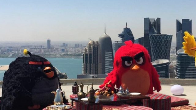 Angry Bird mascots with the city skyline behind them