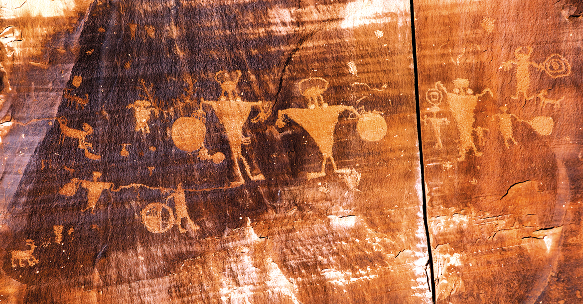 Petroglyphs of horned anthropomorphs holding shields, and abstract images form part of a 125-feet panel engraved on a sheer rockface, a short excursion from Moab in Utah