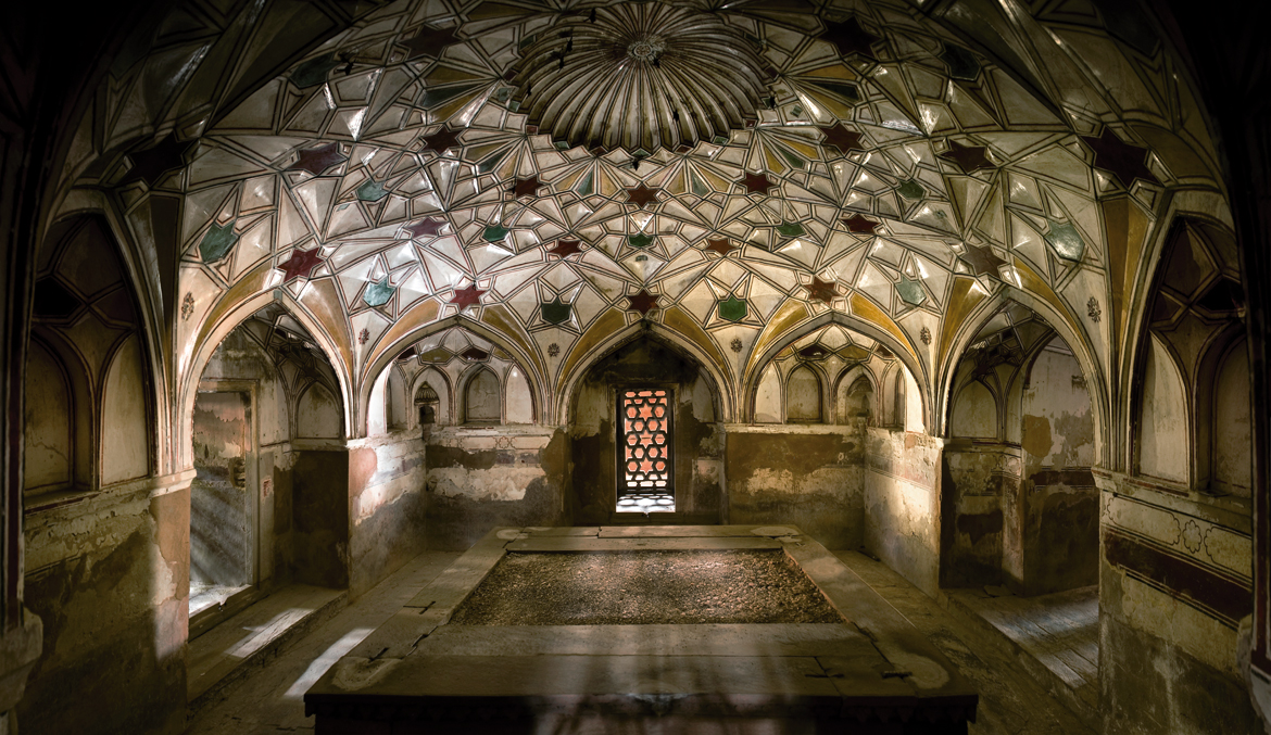 KHUSRAU BAGH, ALLAHABAD: This extensive walled char bagh takes its name from Shah Jahan’s elder brother, who is buried here. Khusrau Bagh is entered from the south through a monumental gate with a lofty arch. Within the garden stands a quartet of tombs along an east–west line. The crypt in this photograph lies inside the tomb of Khusrau’s sister, Sultana Nisar Begum, who died in 1625. Raised on a high podium, this elaborately finished building has portals in the middle of each side, flanked by double tiers of arched recesses. Slender corner octagonal chhatris frame the dome on an octagonal drum. The walls of the interior chamber are lavishly painted with trees and flowering plants; the dome above has a petalled medallion surrounded by rings of arch-net motifs, executed in painted plaster. This tomb is the only one to be provided with a partly underground crypt, which is also roofed with an arch-net dome